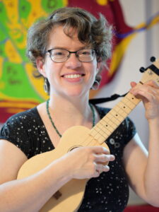Marianne Irmer lächelnd mit Ukulele in der Hand